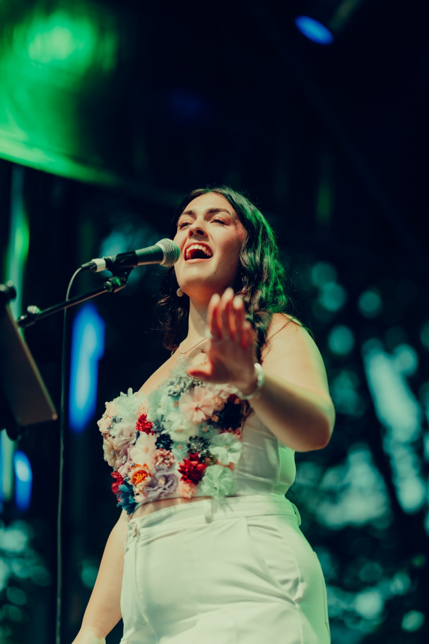 Dana singing on a festival stage in a floral corset