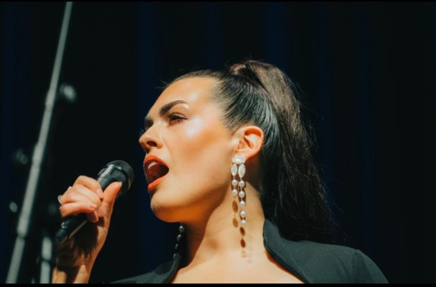 Dana singing, close profile with pearl earrings